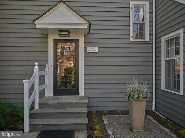 a front view of a house with a potted plant