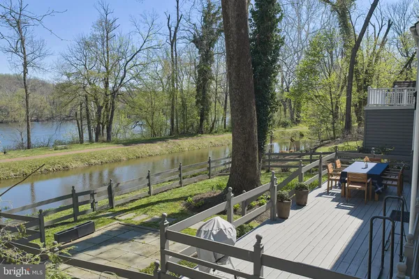 a view of a wooden deck with chairs and a tree
