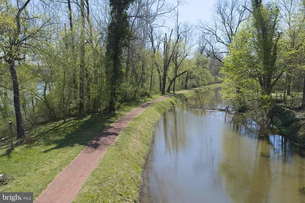 a view of a lake with a yard and large trees