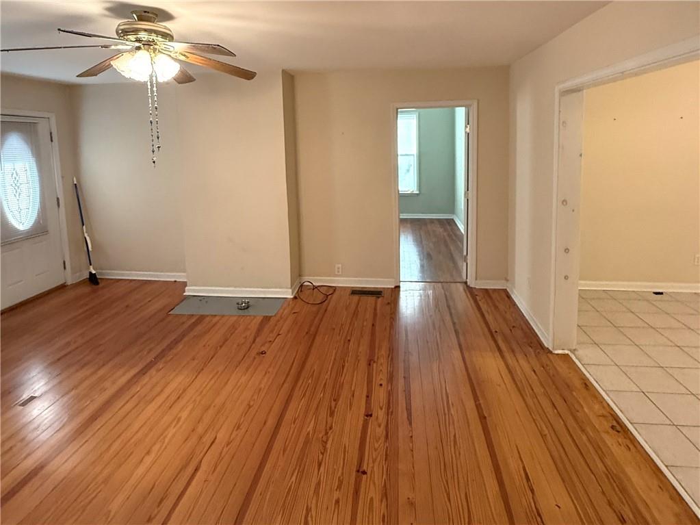 1740 Spring Street Northeast Conyers, GA 30012 - Photo 3 of 23 an empty room with wooden floor fan and windows