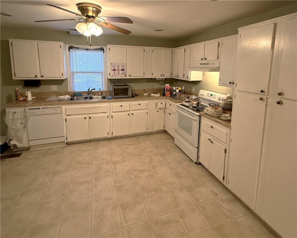 1740 Spring Street Northeast Conyers, GA 30012 - Photo 7 of 23 a kitchen with granite countertop a stove top oven sink and cabinets