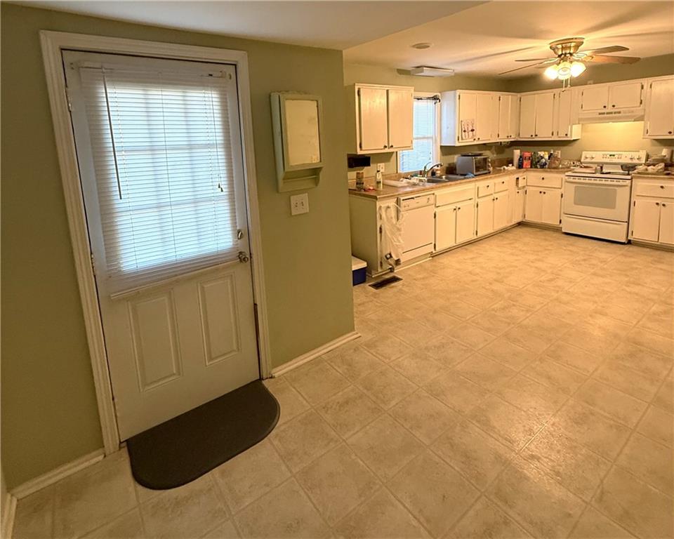 1740 Spring Street Northeast Conyers, GA 30012 - Photo 9 of 23 a large white kitchen with granite countertop a sink