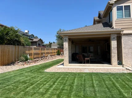 a view of a house with a small yard and wooden fence