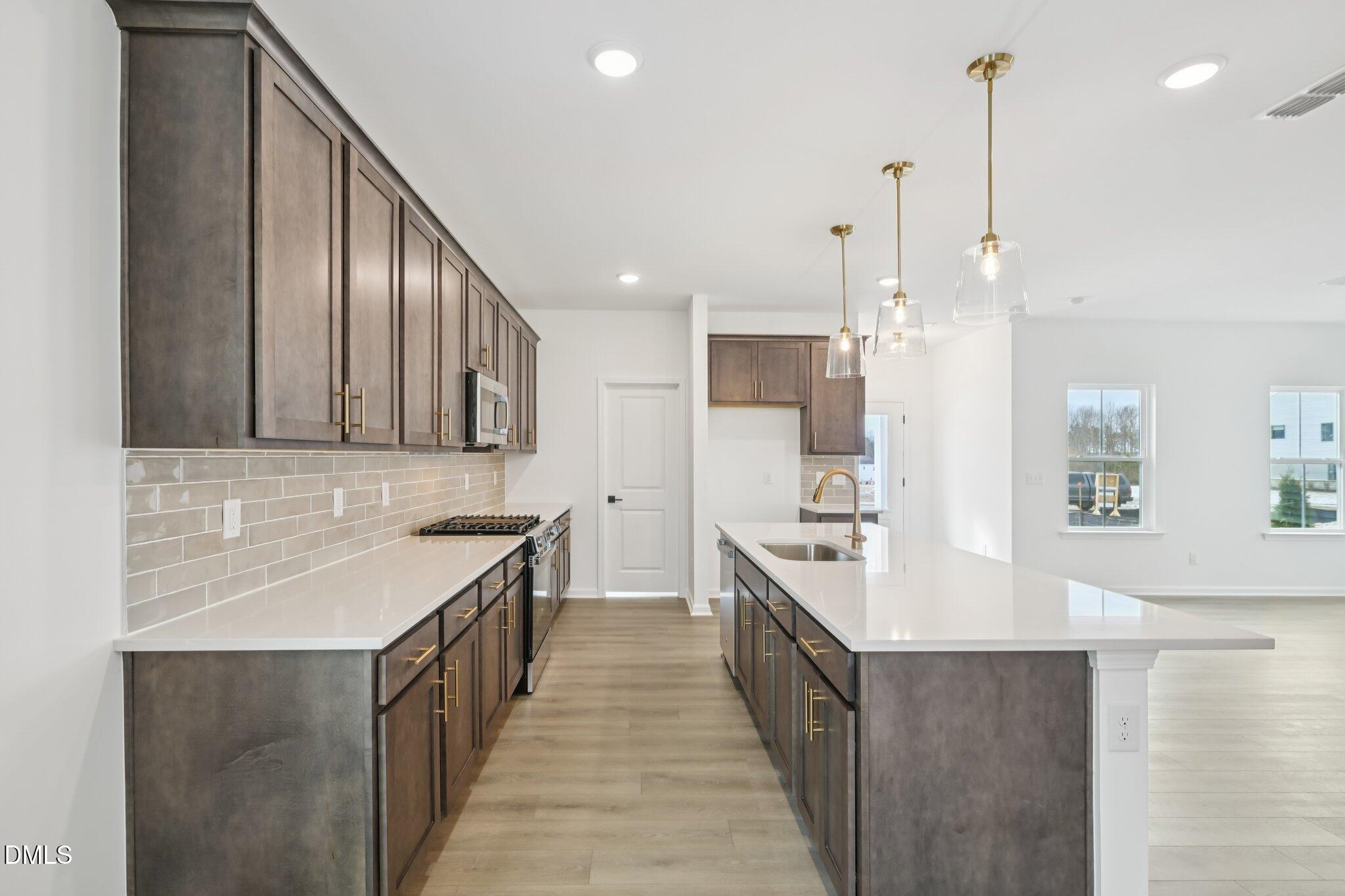 309 Marvel Drive, Unit 147 Rolesville, NC 27571 - Photo 11 of 39 a kitchen with stainless steel appliances a sink stove and cabinets