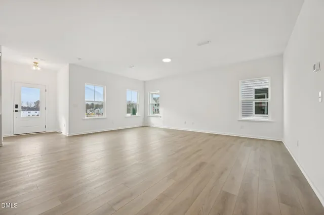 a kitchen with stainless steel appliances granite countertop a sink a stove a refrigerator and island with wooden floor