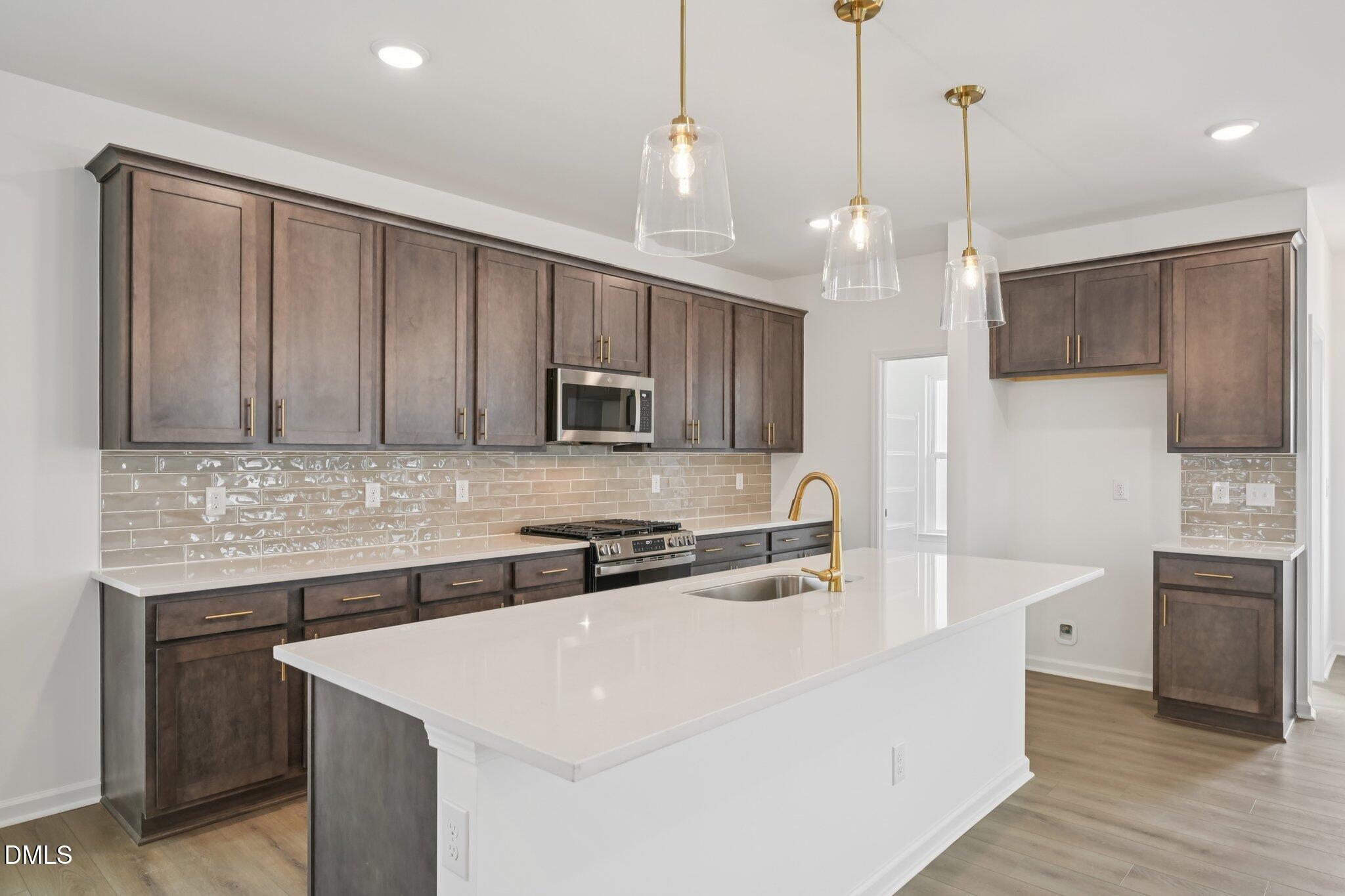 309 Marvel Drive, Unit 147 Rolesville, NC 27571 - Photo 10 of 39 a kitchen with stainless steel appliances granite countertop a sink a stove a refrigerator and island with wooden floor