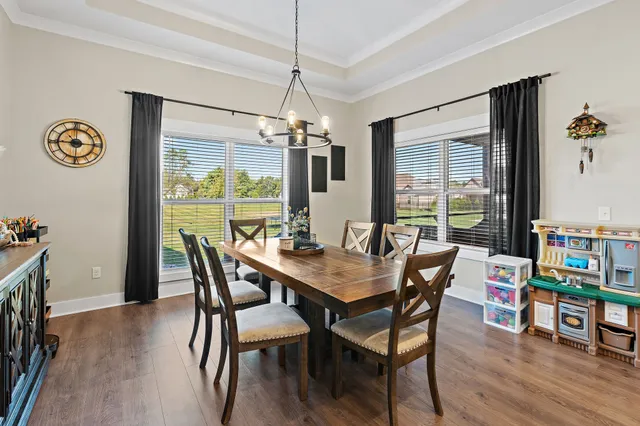 a dining room with furniture and a floor to ceiling window