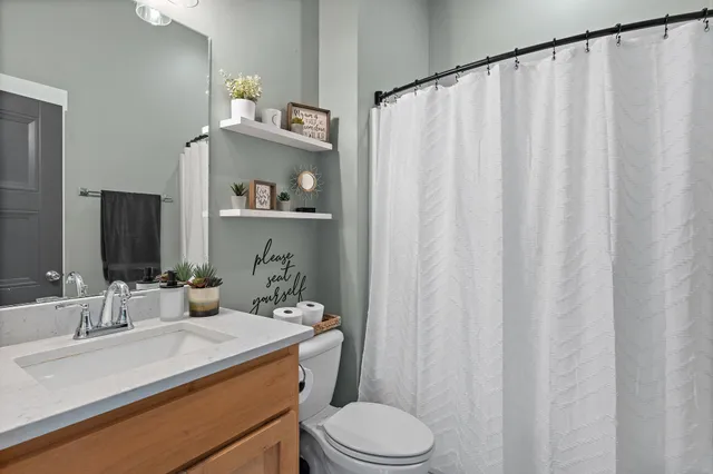 a bathroom with a sink a toilet and shower curtain