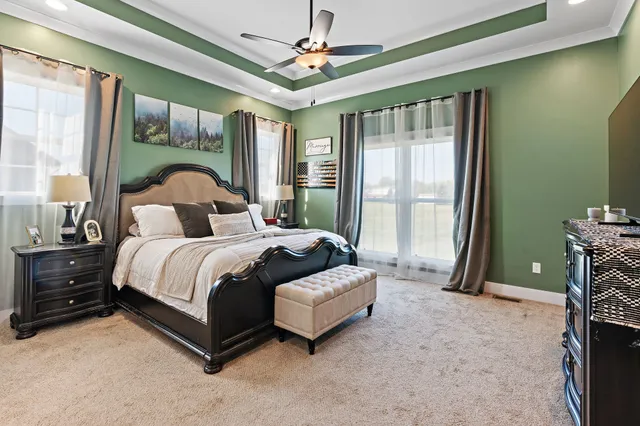 a spacious bedroom with a bed a window and a chandelier
