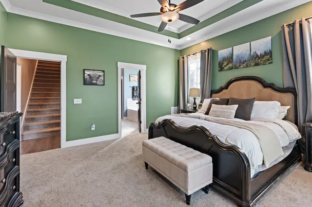 a bedroom with a bed chandelier and a window