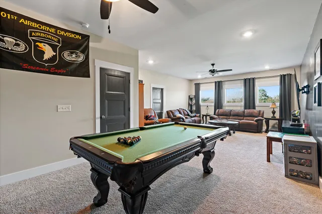 a room with furniture pool table and windows