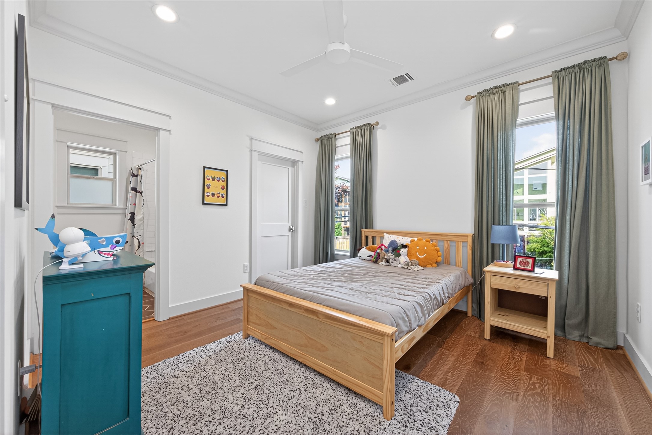515 West 25th Street Houston, TX 77008 - Photo 22 of 35 This 11’10” x 10’11” secondary bedroom offers great natural light through large windows, highlighted by crown molding and a Minka-Aire large-room fan in flat white. The 6’2” x 4’7” walk-in closet adds excellent functionality with built-in shelving, cubbies, and hanging racks designed for efficient storage.