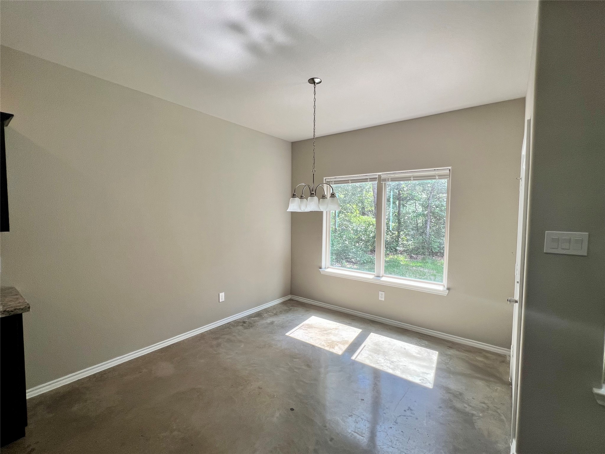 15887 Pecan Drive Montgomery, TX 77356 - Photo 4 of 11 an empty room with a windows and chandelier