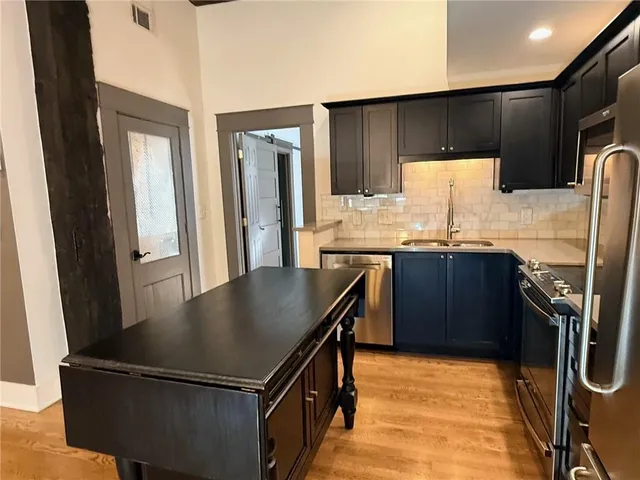 a kitchen with stainless steel appliances granite countertop a sink stove and refrigerator