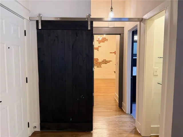 a view of a hallway with wooden floor and staircase