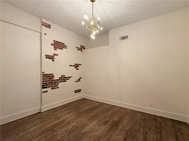 a view of a hallway with wooden floor and chandelier