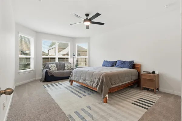 a bedroom with a bed and a ceiling fan