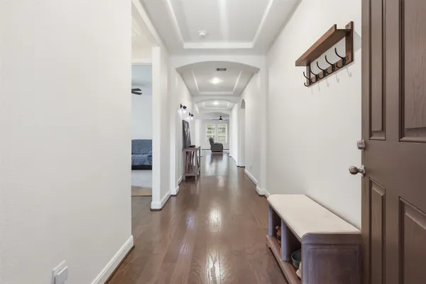 a view of a hallway with wooden floor and staircase