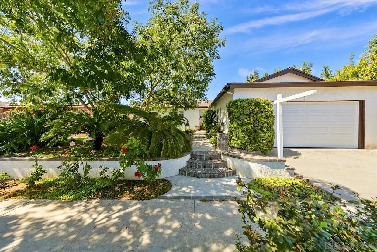2602 Murray Ridge Road San Diego, CA 92123 - Photo 1 of 17 a front view of a house with a yard and garage