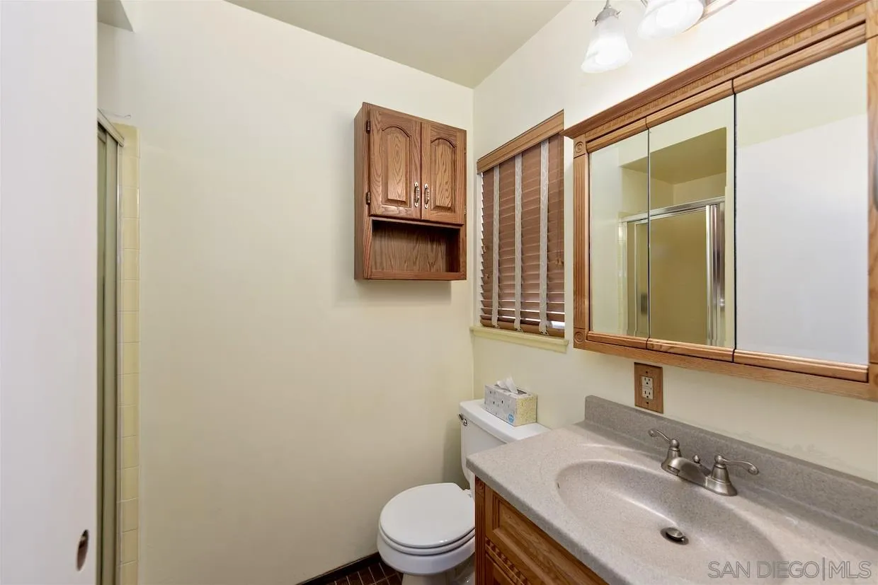 2602 Murray Ridge Road San Diego, CA 92123 - Photo 11 of 17 a bathroom with a granite countertop sink toilet and mirror
