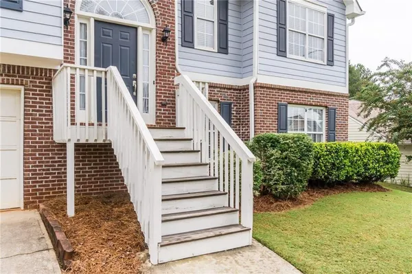 a view of a livingroom with a fireplace a ceiling fan and wooden floor