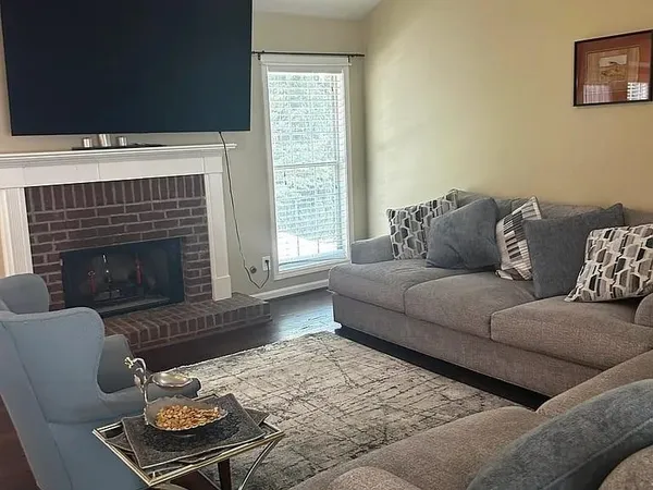 a living room with furniture a flat screen tv and a fireplace