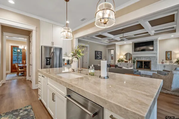 a large kitchen with stainless steel appliances granite countertop a stove oven and a view of dining hall with couches