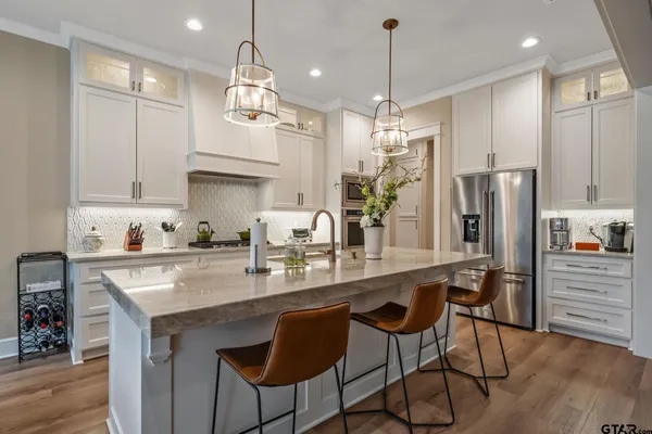 a kitchen with refrigerator a sink and chairs