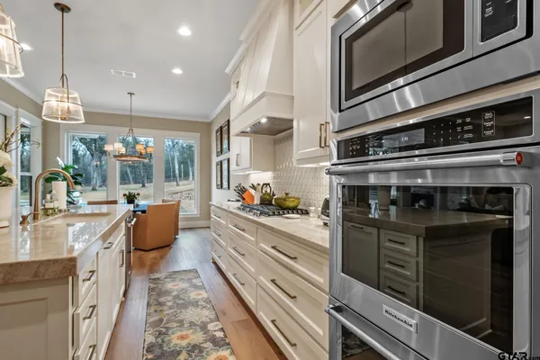 a kitchen with stainless steel appliances kitchen island granite countertop a stove and cabinets