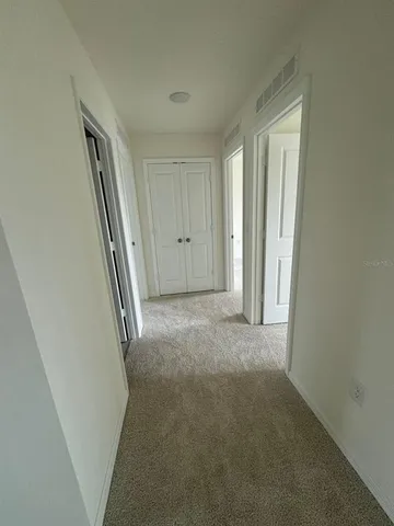 a view of a hallway to rooms