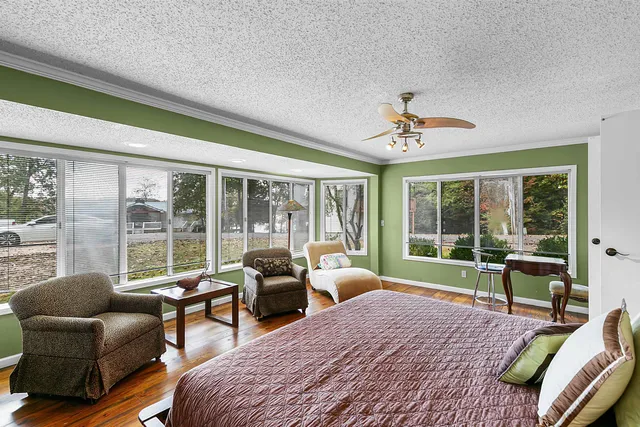 a bedroom with a bed and wooden floor