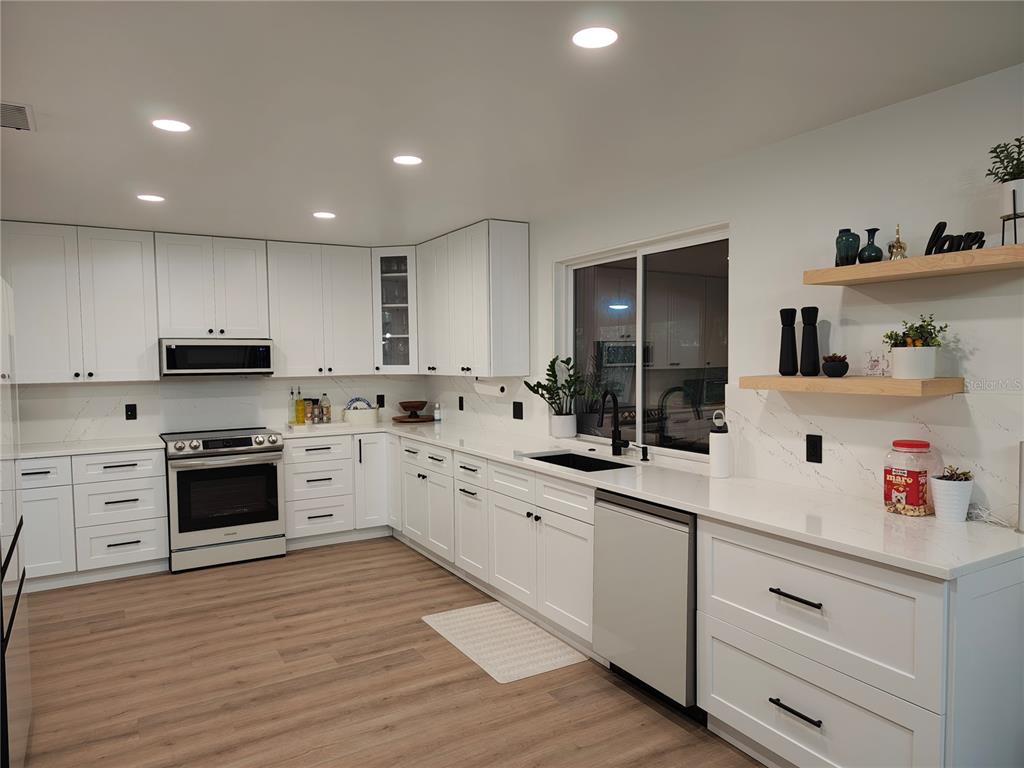 820 North Wekiwa Springs Road Apopka, FL 32712 - Photo 11 of 51 a kitchen with white cabinets stainless steel appliances and sink
