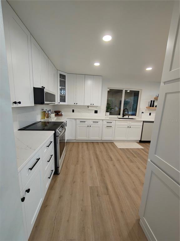 820 North Wekiwa Springs Road Apopka, FL 32712 - Photo 12 of 51 a large kitchen with kitchen island a sink dishwasher stove refrigerator and cabinets
