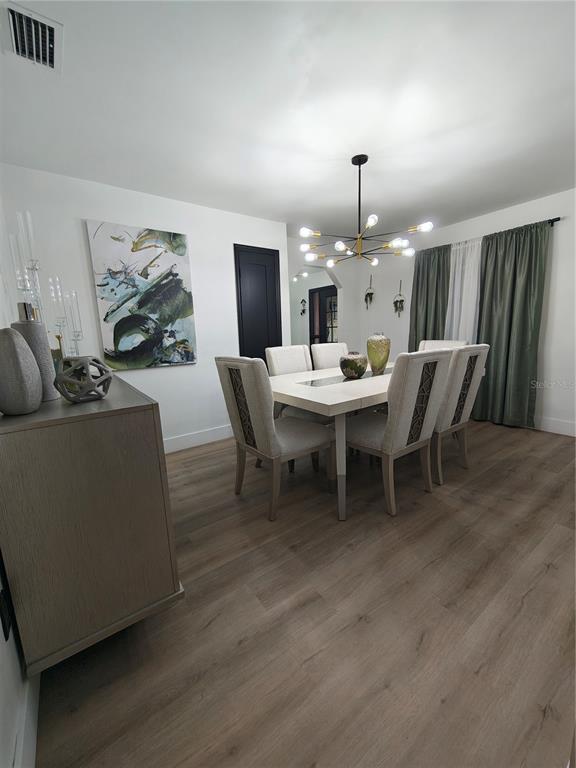 820 North Wekiwa Springs Road Apopka, FL 32712 - Photo 32 of 51 a living room with furniture a dining table and a chandelier