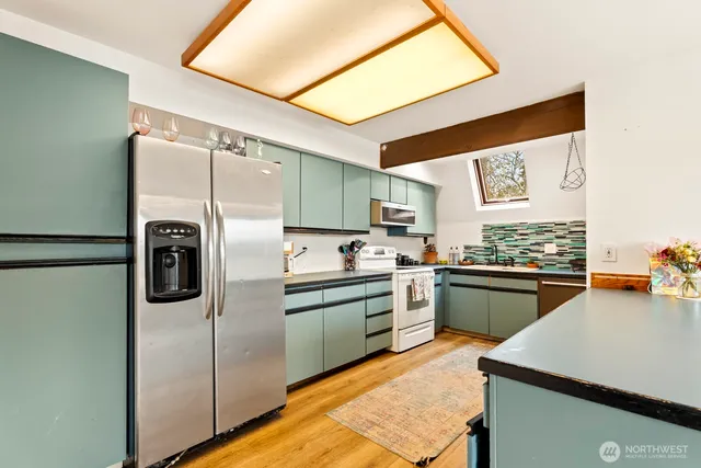 a kitchen with stainless steel appliances granite countertop a refrigerator and a stove