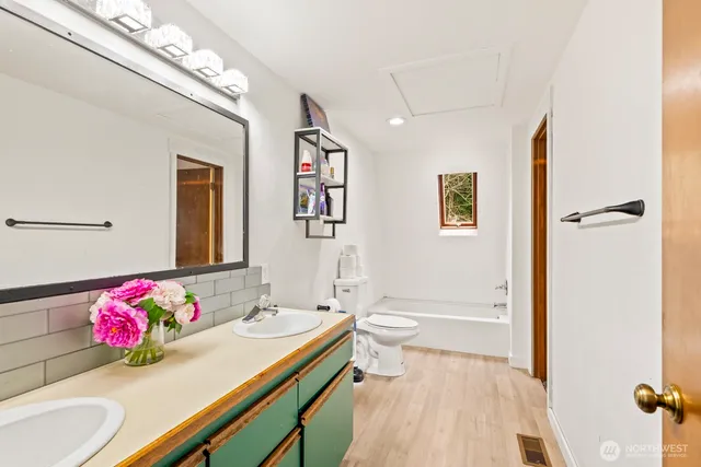 a bathroom with a sink vanity mirror and toilet