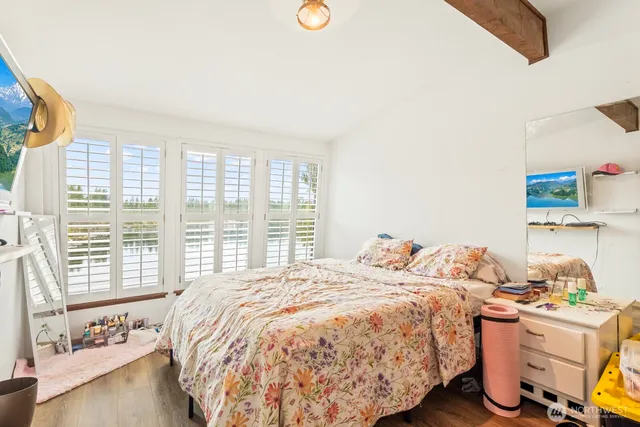 a bedroom with a bed and wooden floor