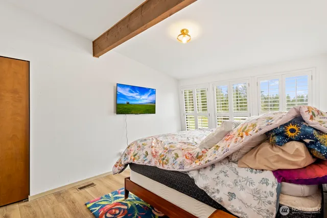 a bedroom with a bed and a painting on the wall