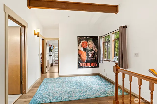 a view of a hallway with wooden floor and windows