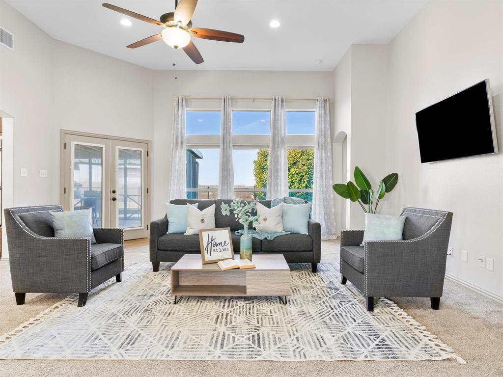 Large living room with floor to ceiling windows and stone fireplace with hearth