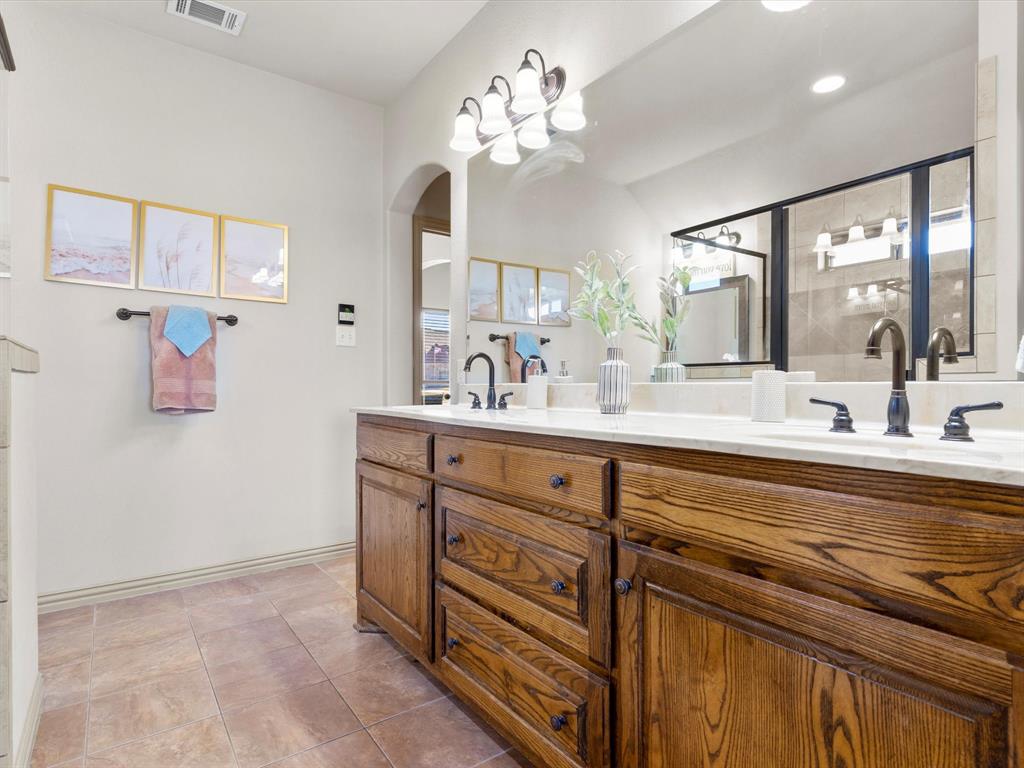 1311 Roe Helm Drive Rhome, TX 76078 - Photo 13 of 35 Large primary bathroom with double vanity and separate makeup table and instant hot water heater