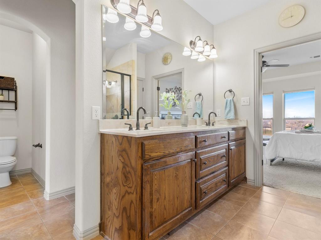 1311 Roe Helm Drive Rhome, TX 76078 - Photo 14 of 35 Large primary bathroom with double vanity and separate makeup table and instant hot water heater