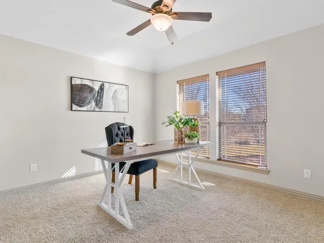 a view of a workspace with furniture and a window