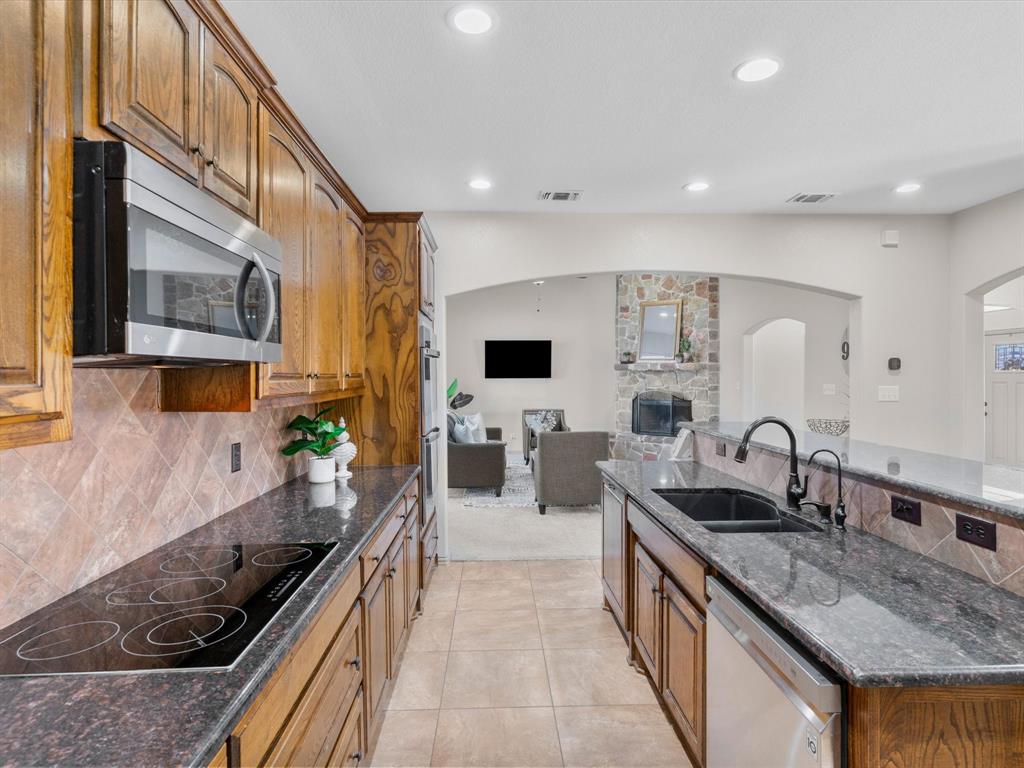 1311 Roe Helm Drive Rhome, TX 76078 - Photo 22 of 35 large chef's kitchen with double ovens, granite counter tops and a bar top for additional seating