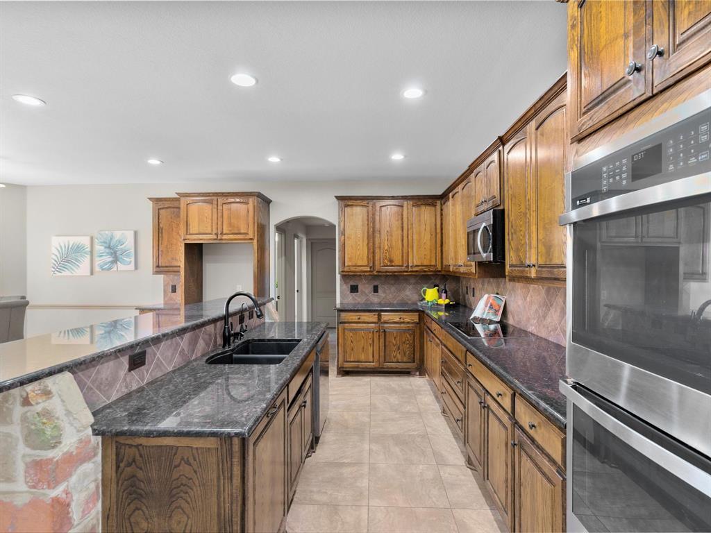 1311 Roe Helm Drive Rhome, TX 76078 - Photo 23 of 35 large chef's kitchen with double ovens, granite counter tops and a bar top for additional seating