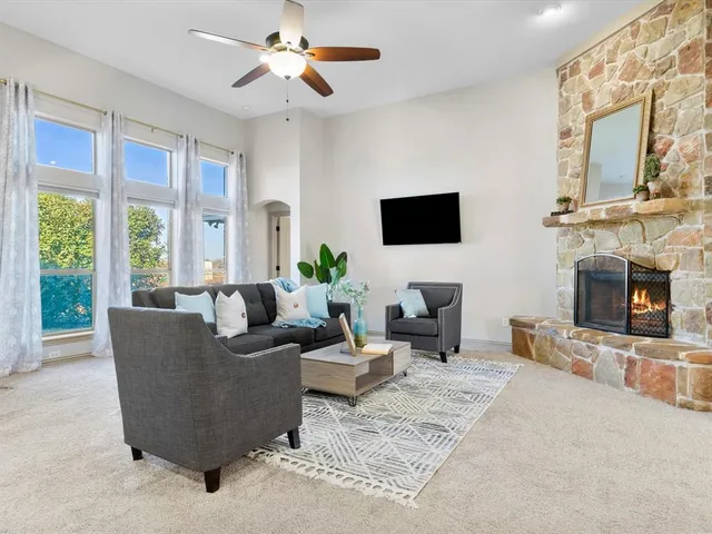 a living room with furniture a fireplace and a flat screen tv