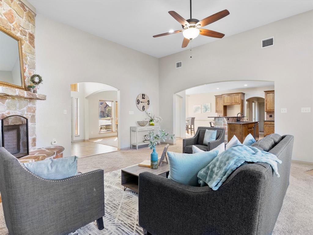 1311 Roe Helm Drive Rhome, TX 76078 - Photo 8 of 35 Large living room with floor to ceiling windows and stone fireplace with hearth