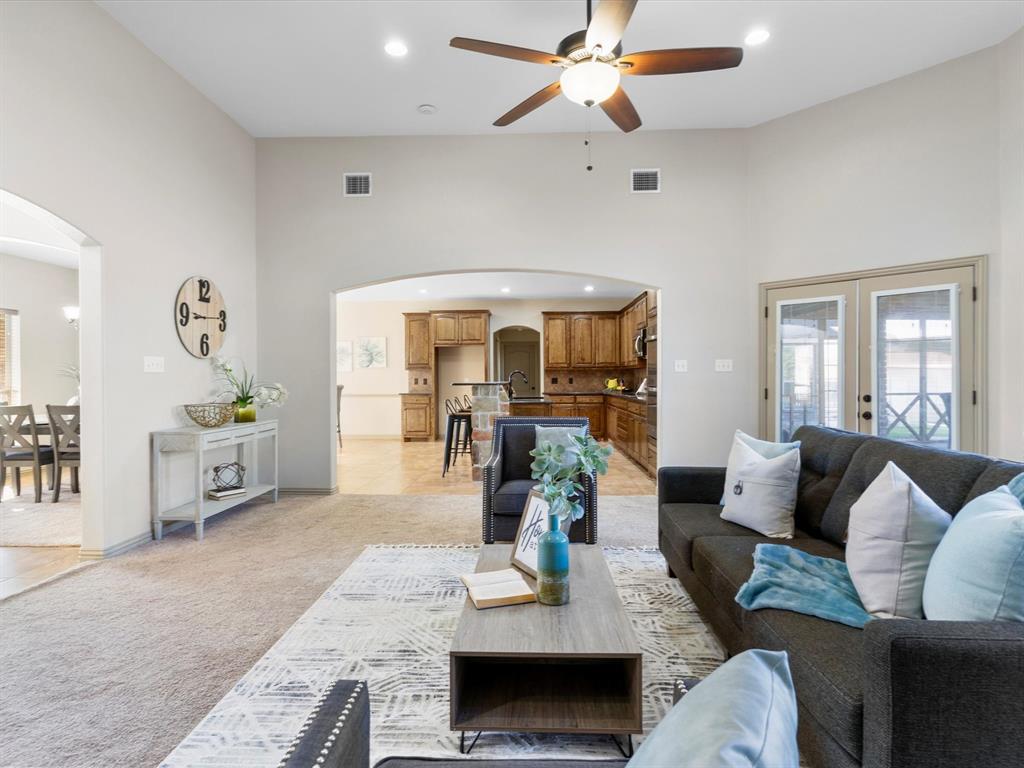 1311 Roe Helm Drive Rhome, TX 76078 - Photo 9 of 35 Large living room with floor to ceiling windows and stone fireplace with hearth