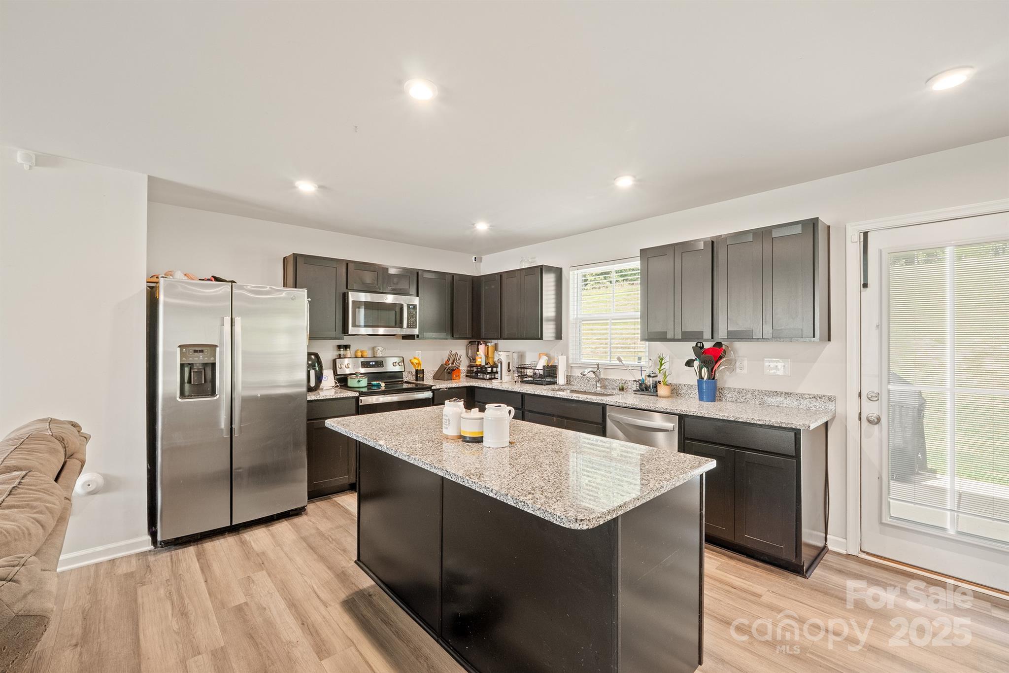 707 Point Andrews Drive Southwest Concord, NC 28025 - Photo 9 of 24 a kitchen with stainless steel appliances granite countertop a sink stove and refrigerator