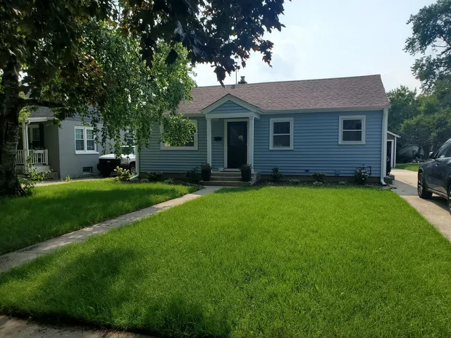 a front view of a house with a garden and yard